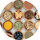 an overhead view of various natural ingredients and powders in small wooden bowls arranged in a circle
